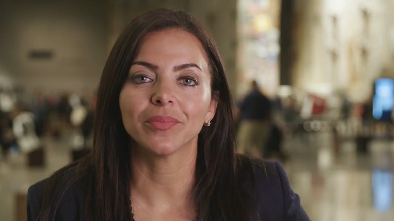 Sofia Lachappell stands in Foundation Hall of the 9/11 Memorial Museum and looks directly into the camera.