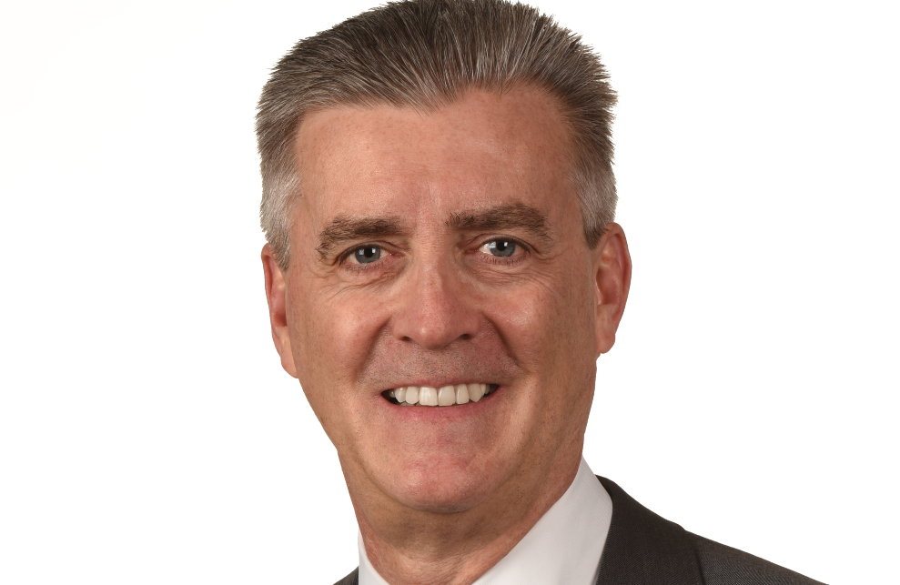 In this headshot, Ambassador Richard Olson is smiling and looking directly at the camera.