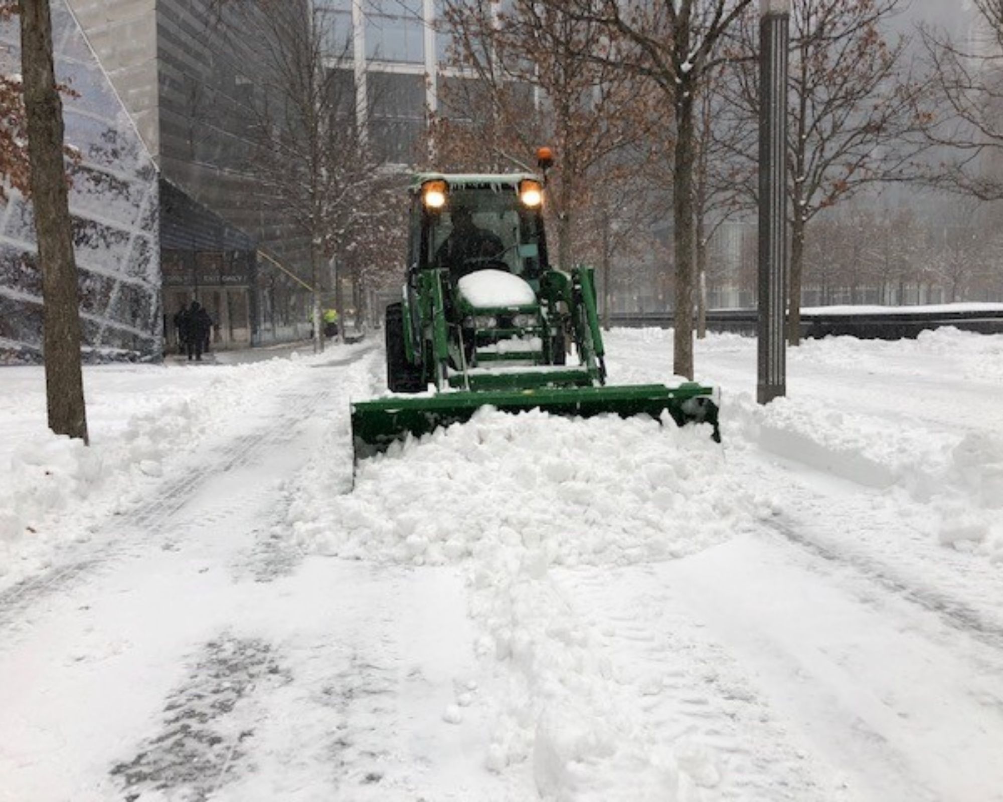 A dark green plough clears a path along the snowy Memorial