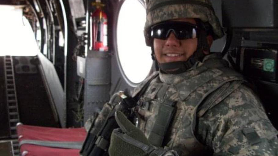 Naveed Shah smiles in army camouflage uniform, inside a military aircraft