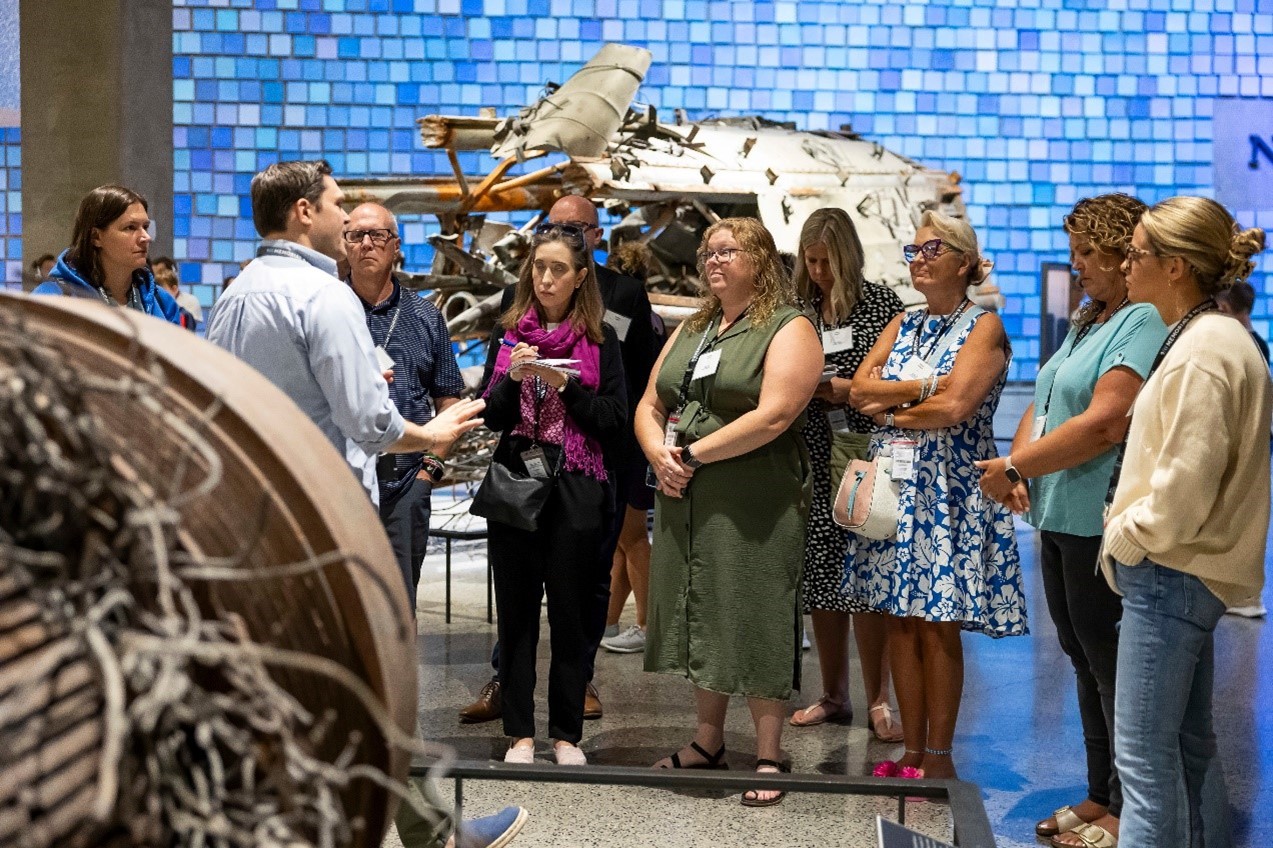 A group of educators listen to a tour guide in front of the Spencer Finch installation at the Museum