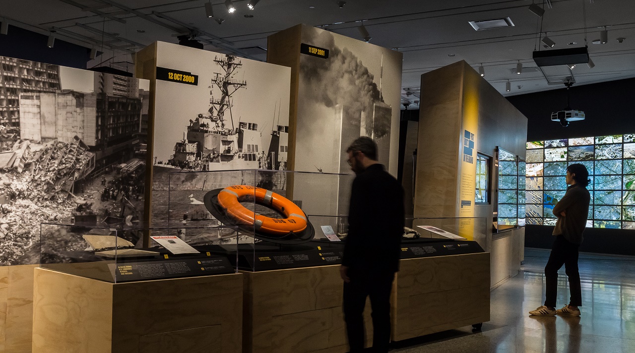 Two individuals observing installations in a gallery space.