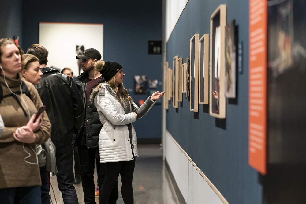 Museum visitors view framed photographs in the exhibition "K-9 Courage."