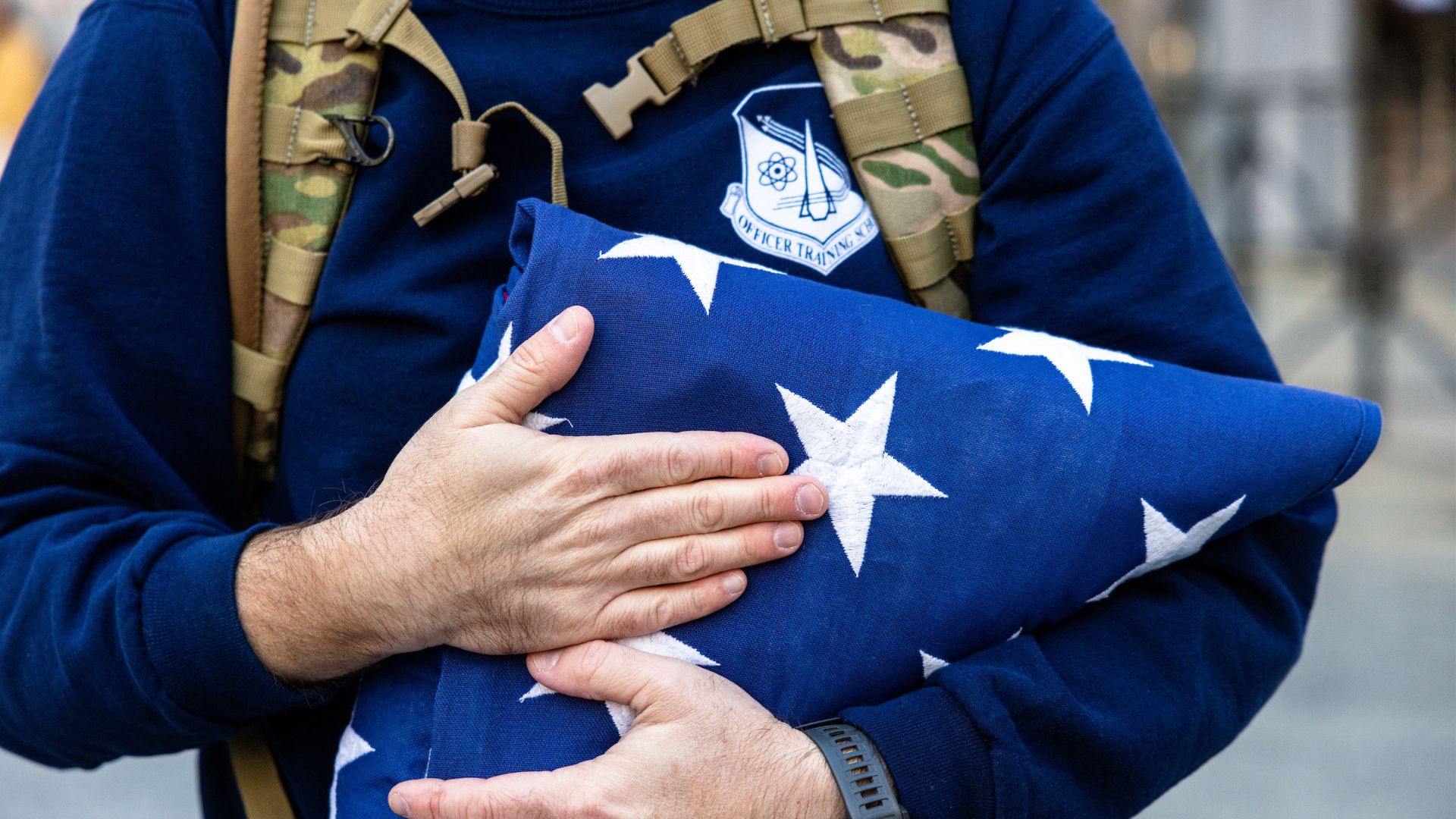 Person carrying a flag folded military style