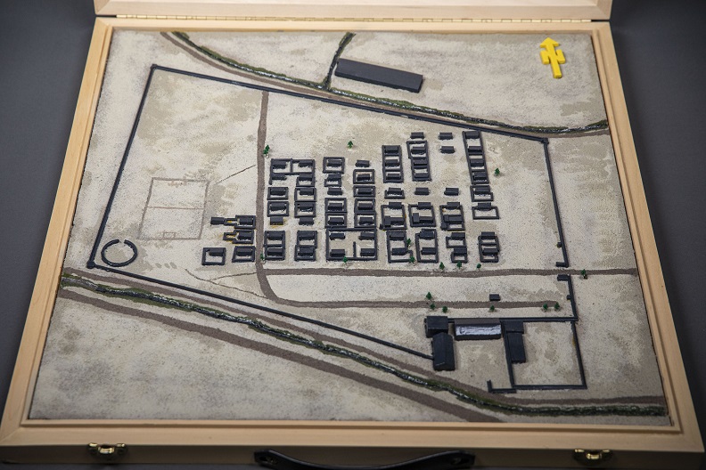 Model showing aerial view of small square buildings lined in multiple rows within a parallelogramic enclosure. 