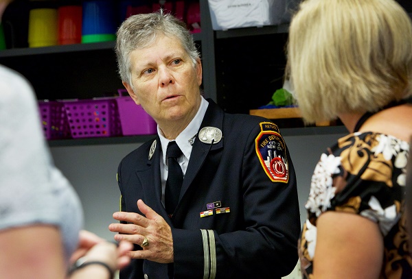 Photo of Brenda Berkman speaking seriously to another woman, whose back is to the camera. 