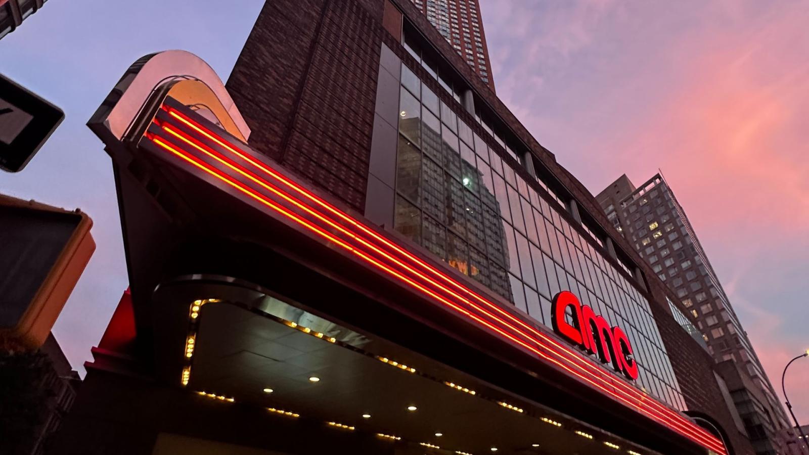 Exterior of an AMC Theatre against a blue, purple, and coral sunset