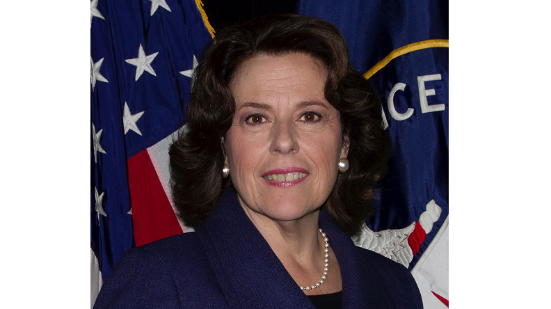 A headshot of Fran Moore, who stands in front of an American flag.